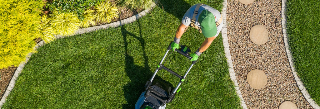 landscaped yard with man mowing